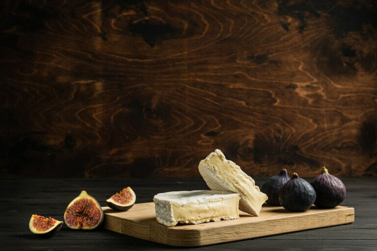 Camembert cheese, fresh figs on a wooden cutting board